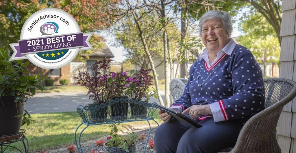Smiling senior woman seated in chair on her patio, a "2021 Best of Senior Living Badge" overlays the image.