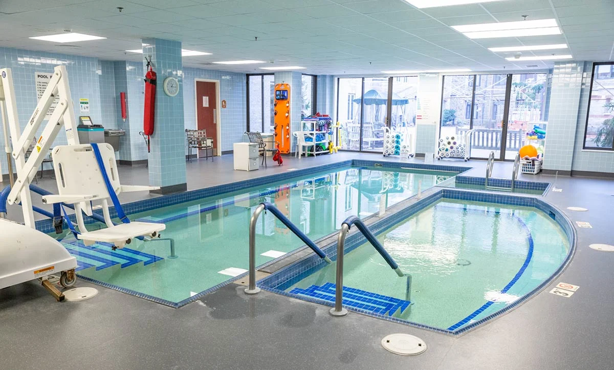 A small indoor pool with accessible chair.