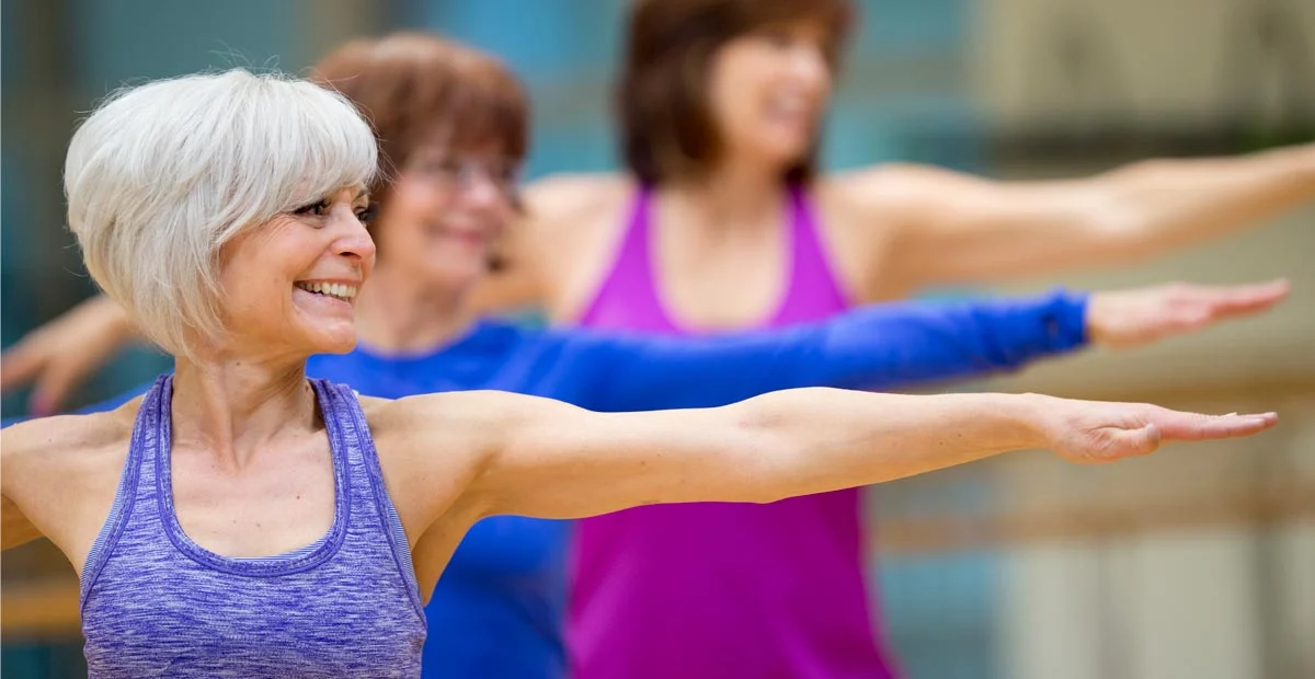 Smiling group of women posing during yoga class.