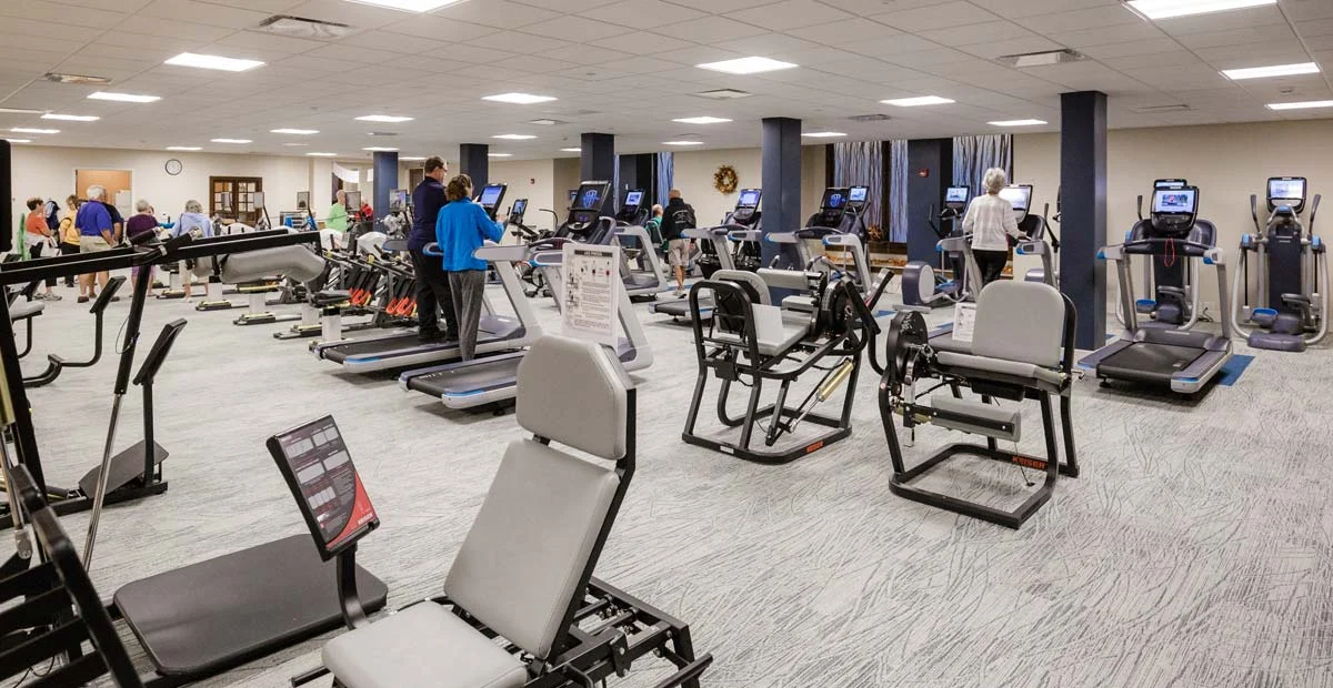 Interior of Baird Wellness Center, a large indoor space with exercise equipment lined up in rows.