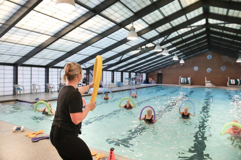 2V9A8781-800×533 Group aquatic exercise class with instructor demonstrating movements outside of pool.