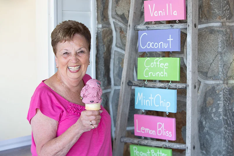 858A2806 Woman smiling outdoors with ice cream cone.