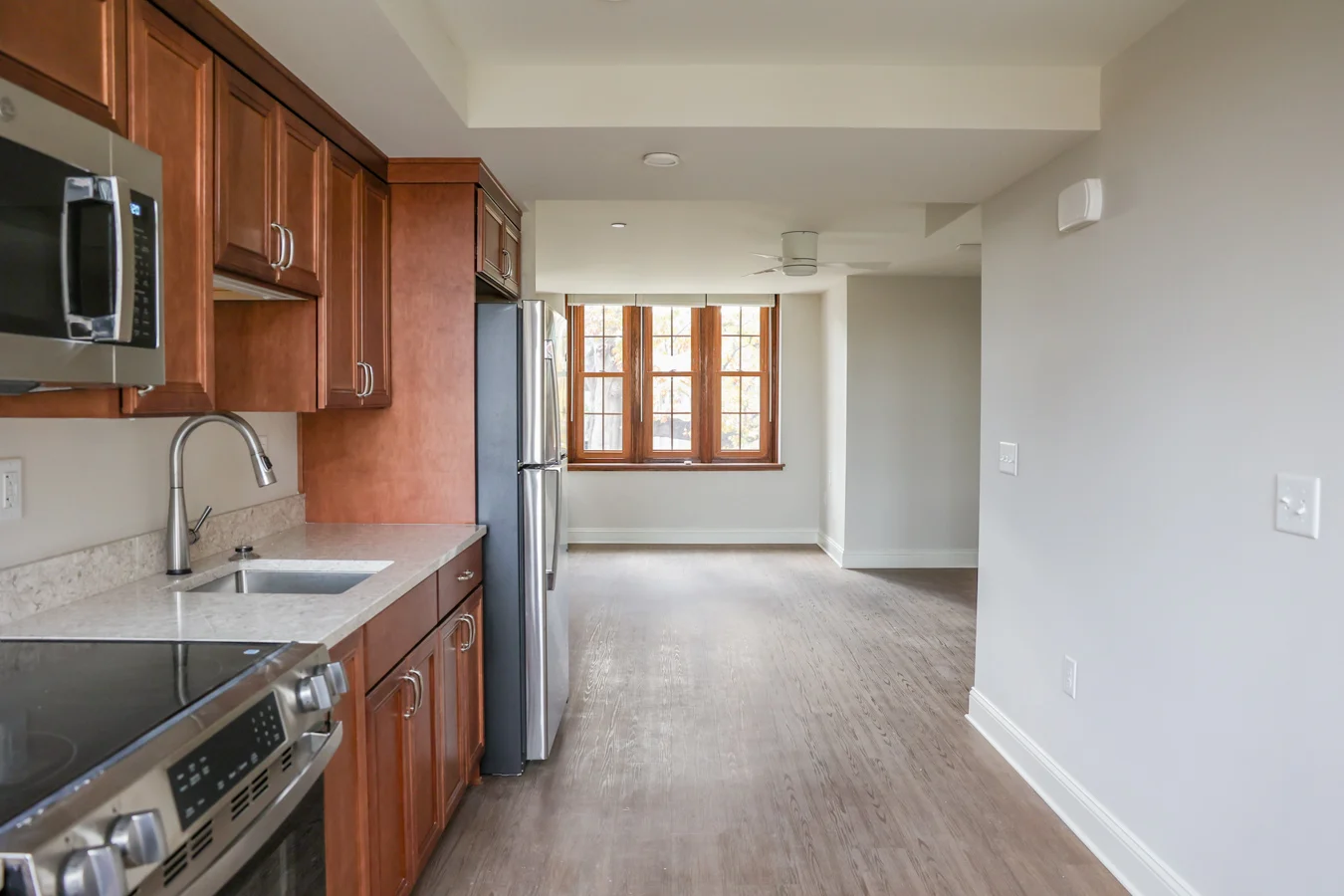 Well-lit kitchen with wooden cabinets.