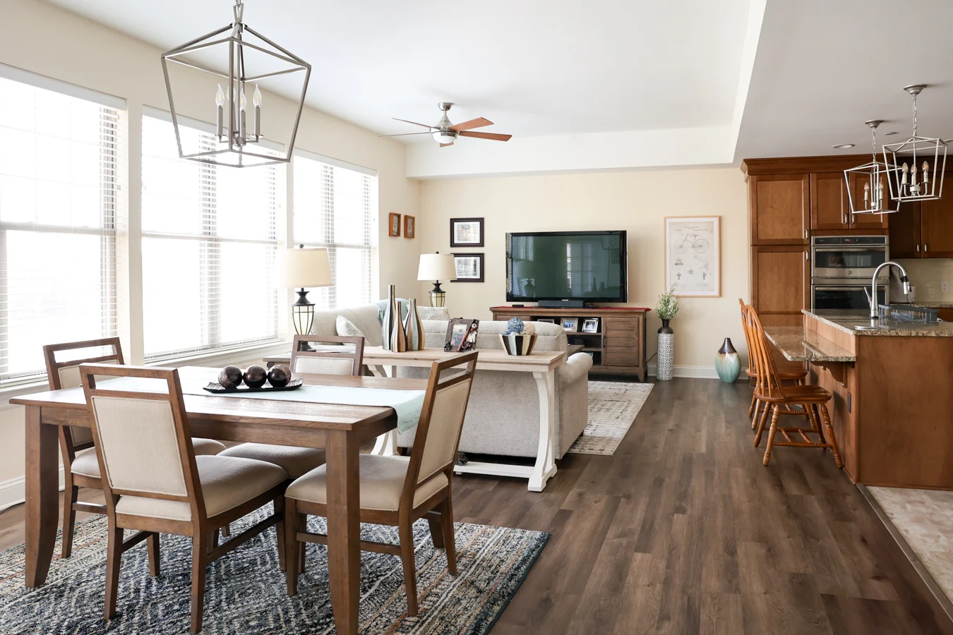 1W8A6031 Brightly lit, well-decorated living room, dining room and kitchen.