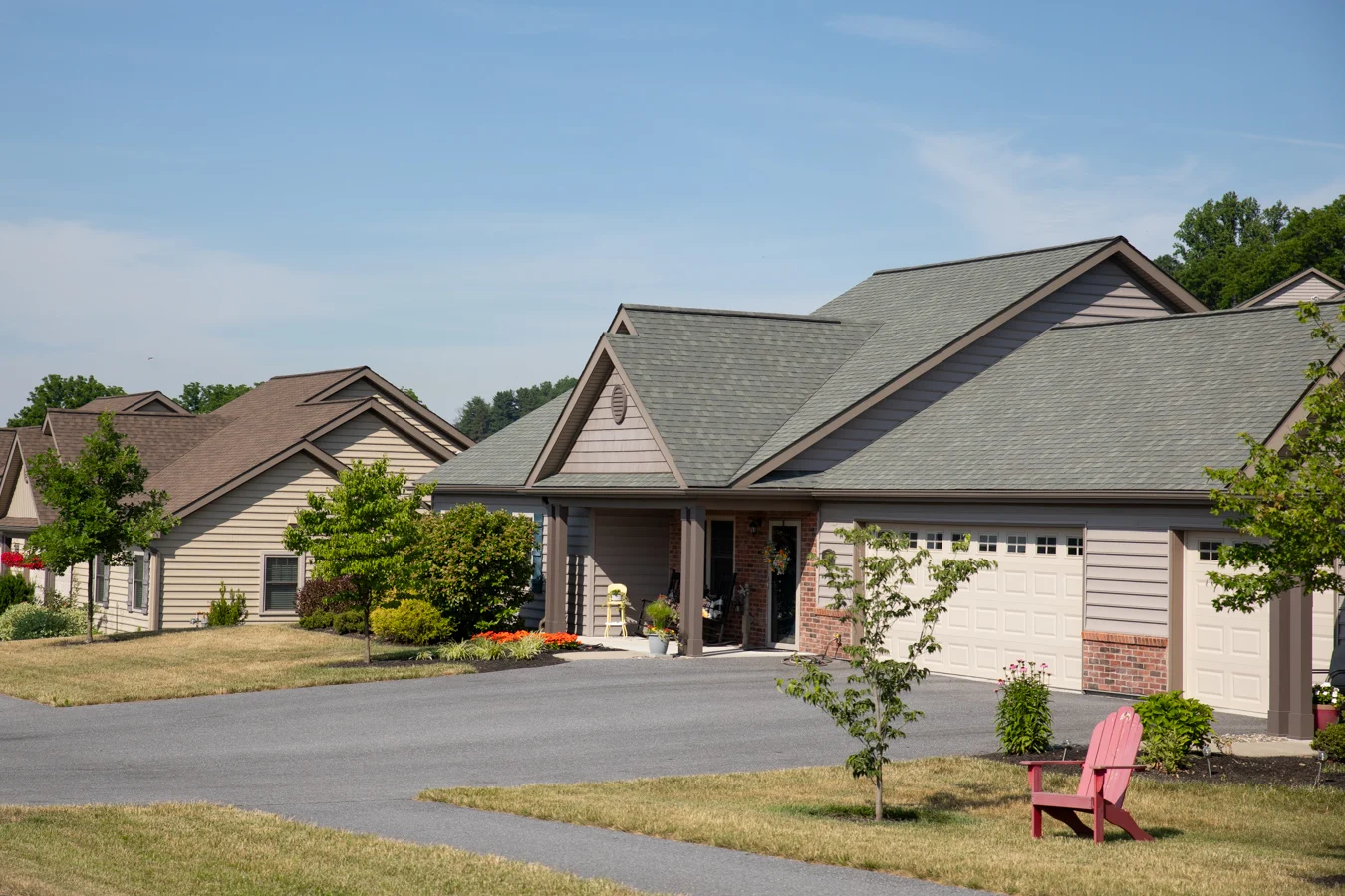 2V9A1371 Cottages with large garages and driveways on a neighborhood street.