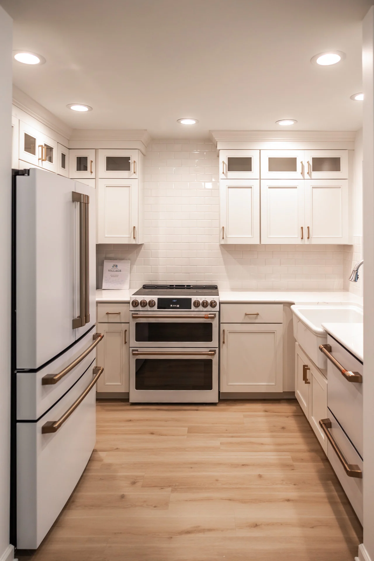 1W8A0662 Brightly lit kitchen with white counters and appliances.