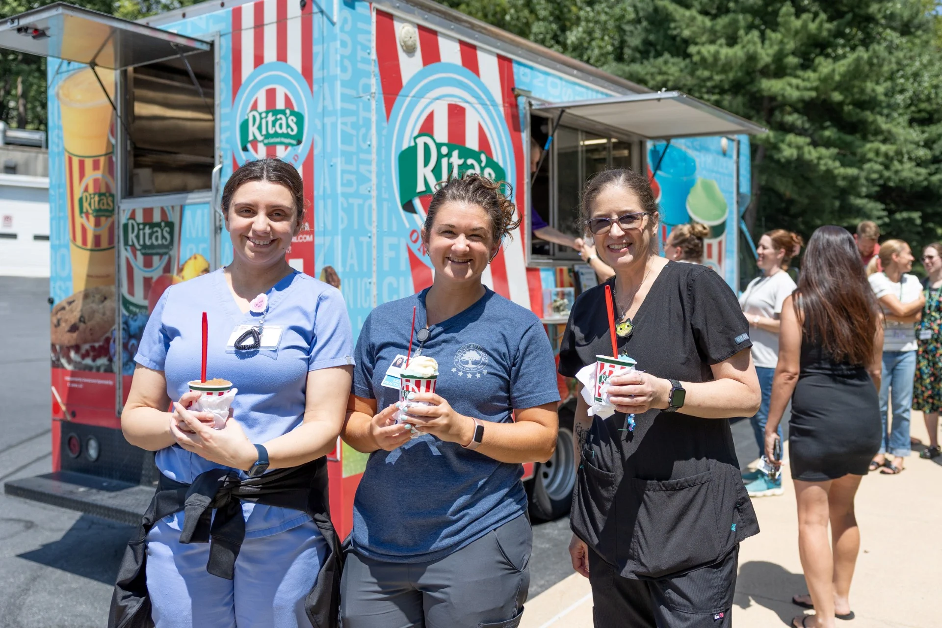Smiling group of women standing in front of Rita's truck.